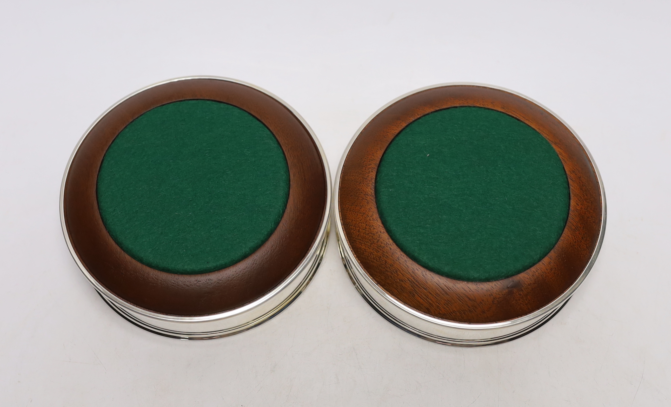 A pair of Elizabeth II silver mounted wine coasters, with turned wooden bases, Roberts & Dore, Sheffield, 2002, diameter 12.4cm, each individually boxed.